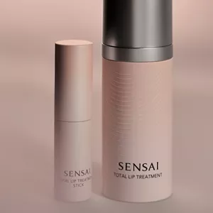 Total Lip Treatment and Stick next to each other with pink mood lighting background